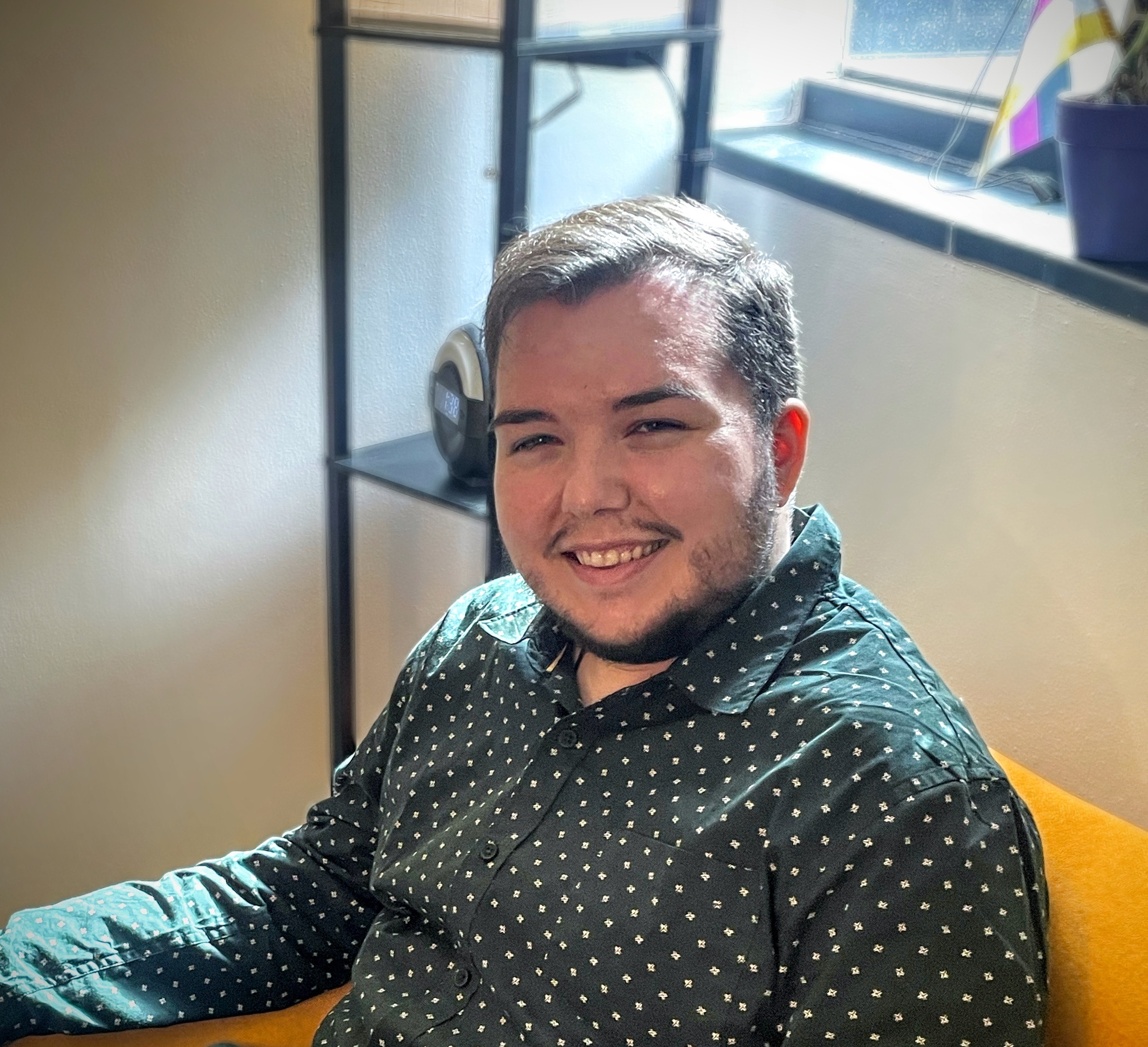 Christopher Lemaire sitting in a yellow chair in his therapy office